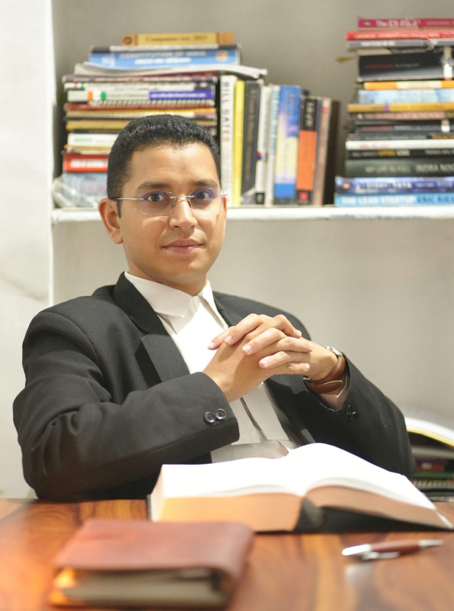 Professional portrait of Advocate Ankit Chamoli in legal attire with bookshelf background